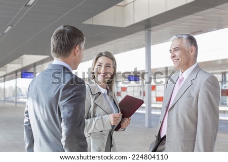 Business people conversing on train platform