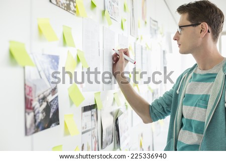Creative businessman writing on paper in office