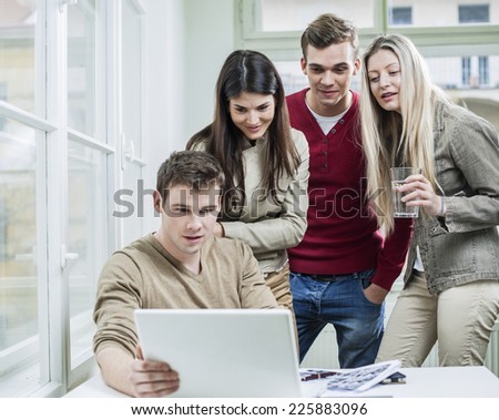 Young business people looking at laptop in meeting