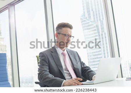 Mature businessman using laptop in office