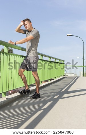 Full length of tired man wiping sweat on bridge after jogging