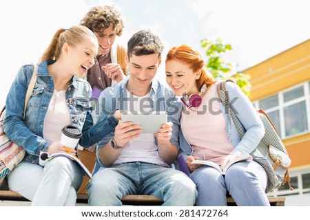 Young students using digital tablet at college campus