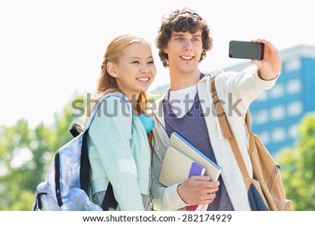 University friends taking selfie with smart phone at campus