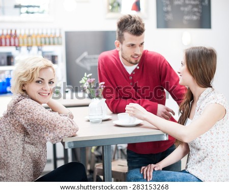 Portrait of smiling woman with friend at cafe table