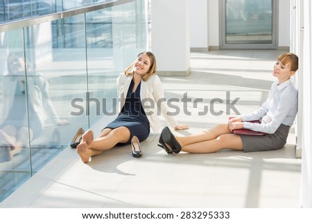 Tired businesswoman relaxing at office hallway