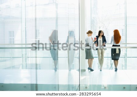 Businesswomen conversing at office hallway