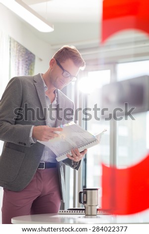 Businessman reading file in creative office