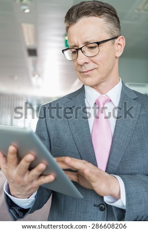 Middle-aged businessman using tablet PC in office