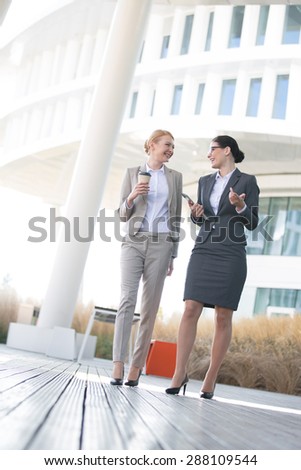 Full-length of businesswomen conversing outside office building