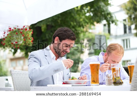Businessmen eating food at outdoor restaurant