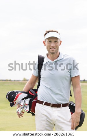 Portrait of confident man carrying golf club bag against clear sky