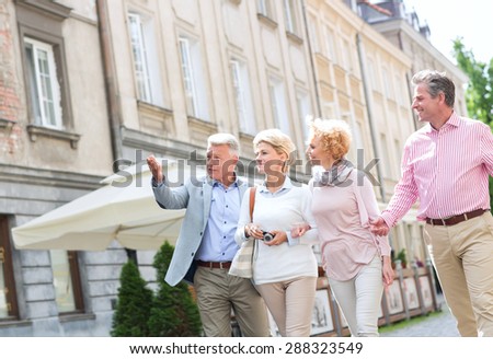 Man showing something to friends while walking in city