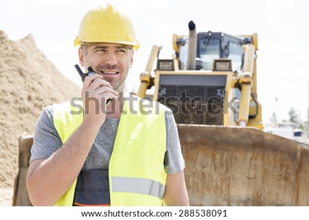 Confident supervisor using walkie-talkie at construction site