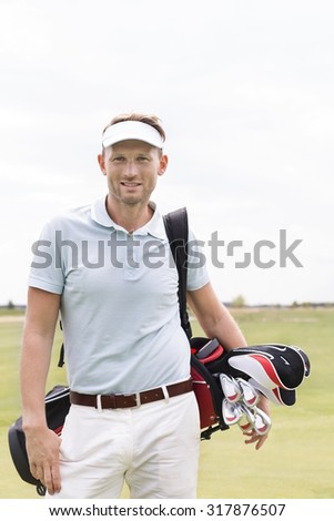 Portrait of confident man carrying golf club bag against clear sky