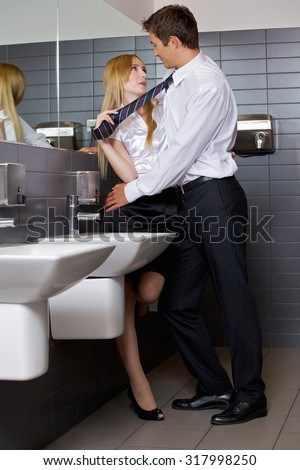 Young business couple flirting with each other at office washroom