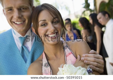 Well-dressed teenage couple standing outside school dance