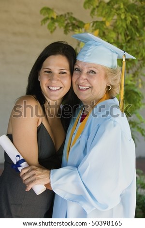 Senior graduate hugging granddaughter outside