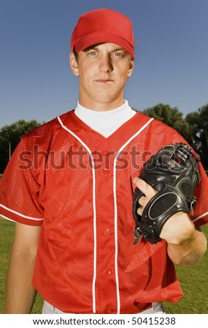Baseball pitcher holding glove, (portrait)
