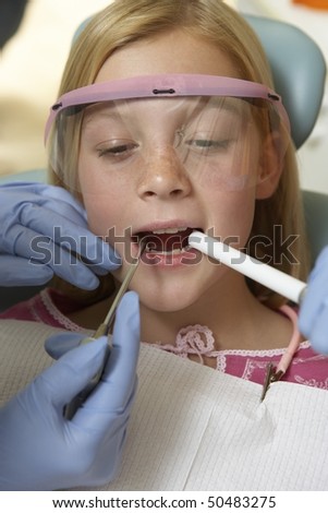 Girl (7-10) having teeth examined at dentists, (close-up)