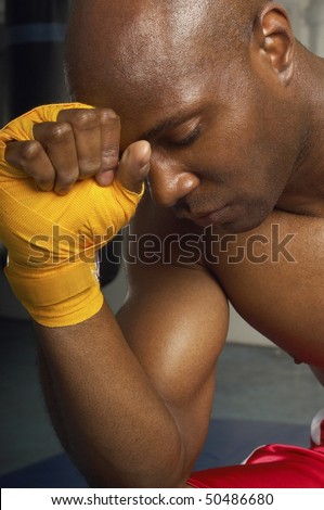 Boxer with head on wrapped hand, head and shoulders