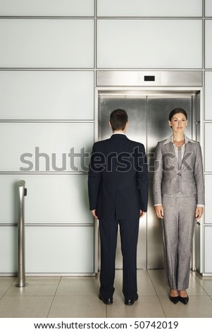 Businesspeople standing In and Out of Office Elevator