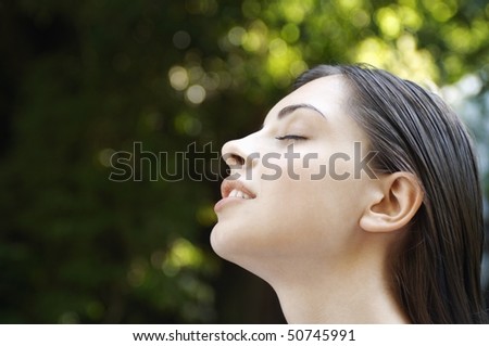 Young woman with closed eyes in forest, close up of head