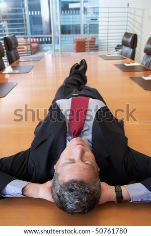 Businessman lying on conference table