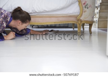 Woman reaching for slippers under bed