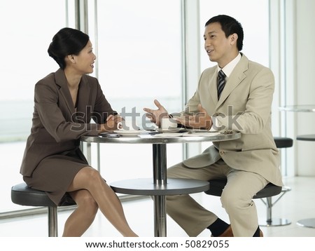Businesspeople Sitting at table, talking to each other