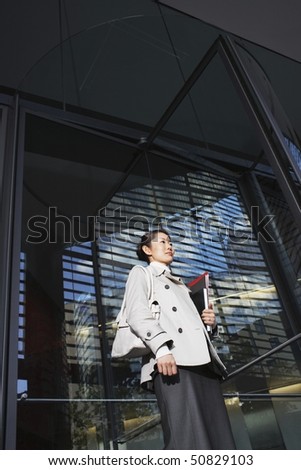 Woman Carrying Notebooks, standing outside, low angle view