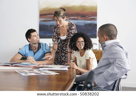 Businesspeople holding a meeting at the end of a conference table
