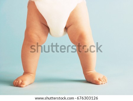 Similar – Image, Stock Photo Toddler standing with legs apart while holding onto to crib rails: nursery with peach, gray and white decor