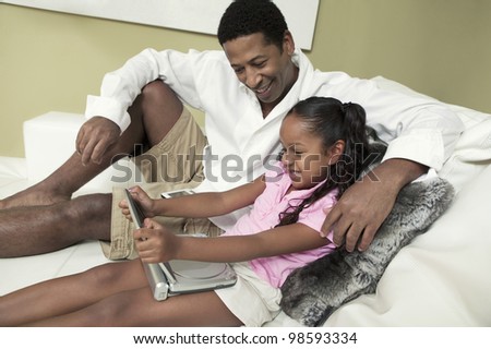 Father and Daughter Watching Movie on Portable DVD Player