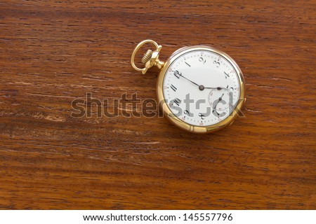 antique gold pocket watch at 5 o\'clock.  Illustration of the passing of time, deadlines, history and tradition.