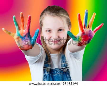 young happy girl.  Child hands painted in colorful paints. Children\'s hand in the paint  on colorful background