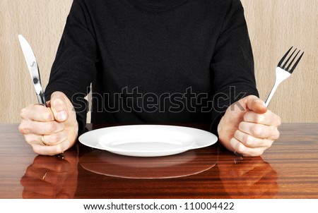 Plug and knife in hands with plate