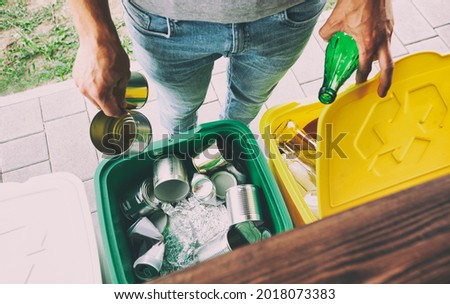 Man throwing the glass bottle and tin can into different dustbins for sorting trash Stockfoto © 