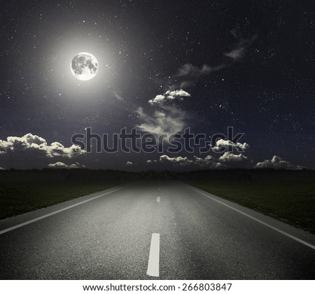 Asphalt road through the green field and moonlight. Elements of this image furnished by NASA