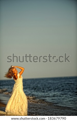 A picture of a beautiful bride on the beach. Romantic moment thinking about the future.