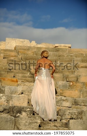 Gorgeous elegant woman at a beautiful antique Roman amphitheater.