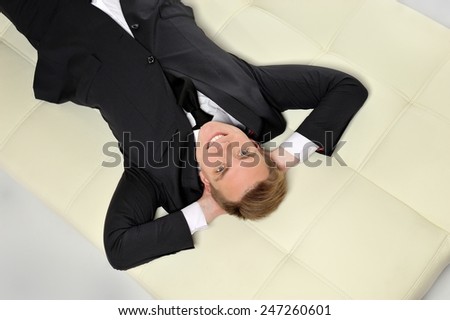 Businessman lying on the couch. Business well, life is good.