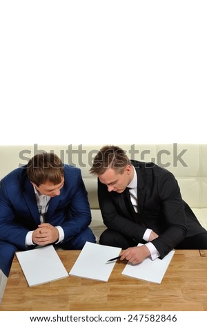 Two people sharing information. Or two business men in the negotiation process. Copy space above and magazine pages for your text.