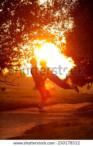 Love couple spinning in the sunset. Sun flare photo.
