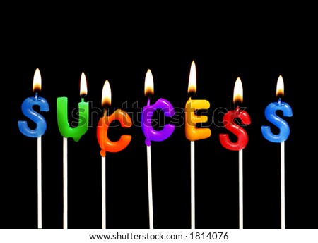 Colorful rainbow candles spelling out success in a business celebration