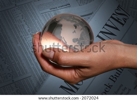 Woman holding glass globe with a business newspaper background