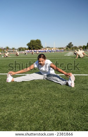 A woman stretching on the football field