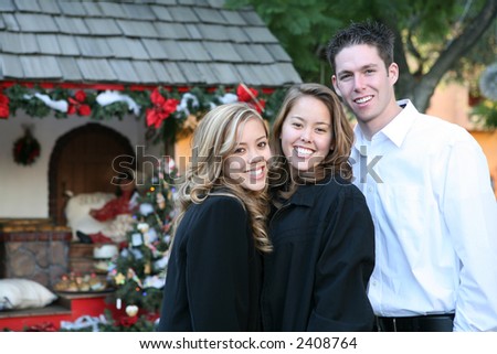 Two sisters, one with boyfriend at a Christmas display in the park