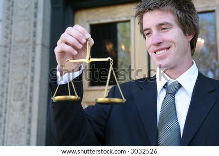 A business man holding a justice scale outside the court building