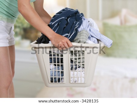 Woman holding the dirty laundry in the bedroom
