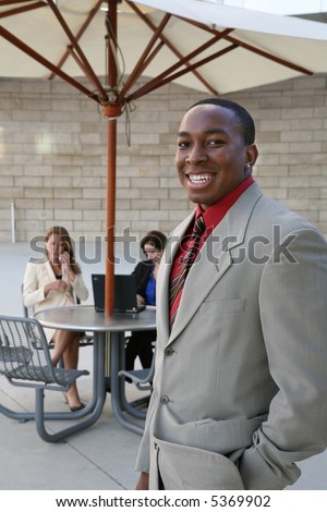 A handsome business man in front of work group
